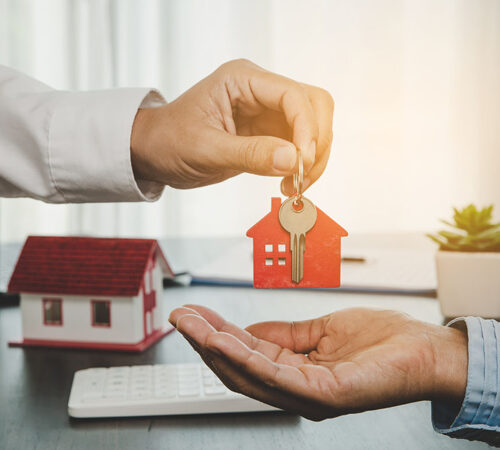real estate agent holding house key to his client after signing contract, concept for business loan, investment mortgage, real estate, moving home or renting property.